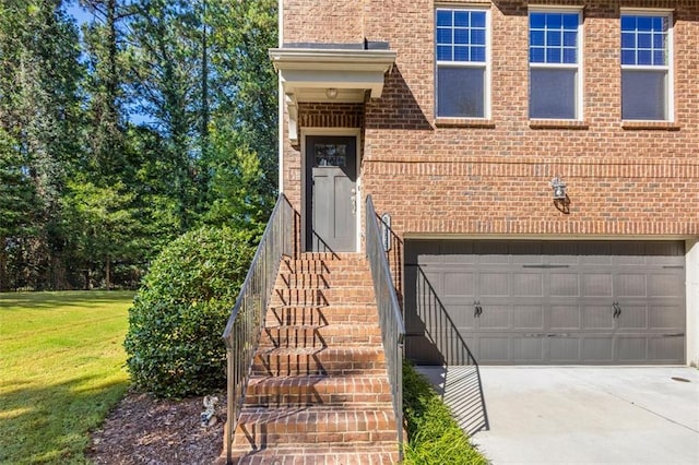 property entrance featuring a garage and a lawn