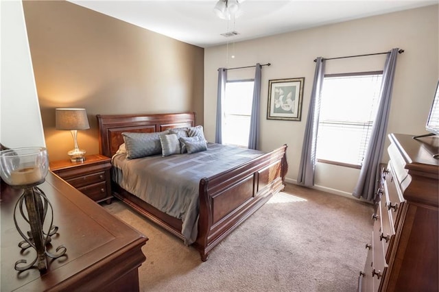 bedroom featuring multiple windows, ceiling fan, and light carpet