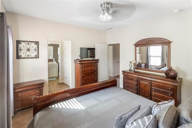 bedroom with light carpet, stainless steel fridge, ensuite bath, and ceiling fan