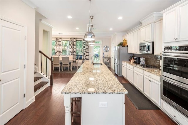 kitchen with white cabinetry, a large island, sink, backsplash, and appliances with stainless steel finishes