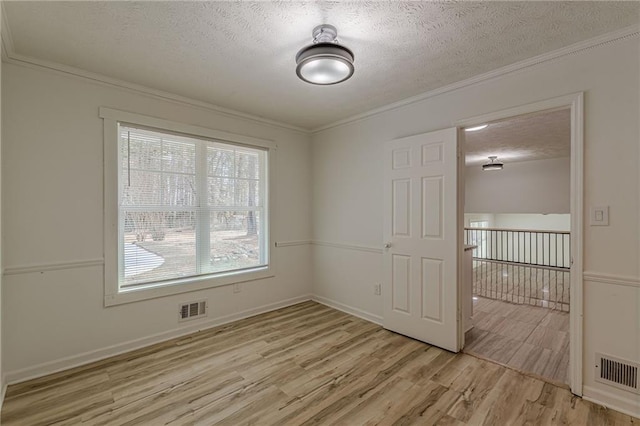 7020 Camp Valley Rd, Riverdale, GA 30296 - spare room with a textured ceiling, ornamental molding, light wood-style flooring, and visible vents