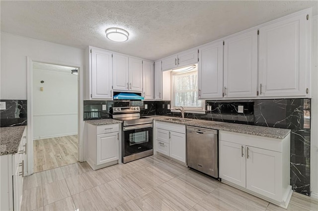 7020 Camp Valley Rd, Riverdale, GA 30296 - kitchen with decorative backsplash, a sink, white cabinets, under cabinet range hood, and stainless steel appliances