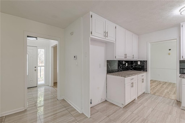 7020 Camp Valley Rd, Riverdale, GA 30296 - kitchen featuring baseboards, a textured ceiling, white cabinets, and tasteful backsplash