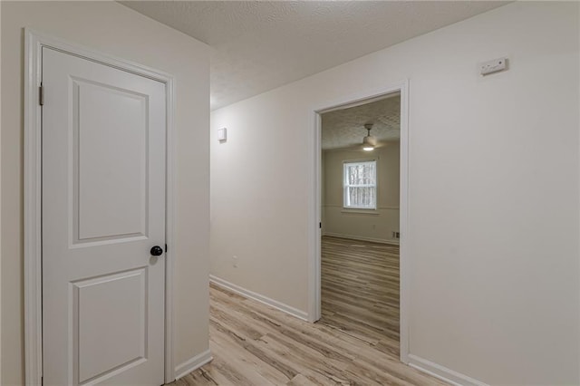 7020 Camp Valley Rd, Riverdale, GA 30296 - hall featuring a textured ceiling, baseboards, and light wood-style floors