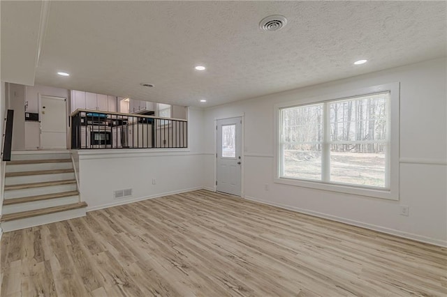 7020 Camp Valley Rd, Riverdale, GA 30296 - unfurnished living room with visible vents, recessed lighting, light wood-style flooring, and stairway