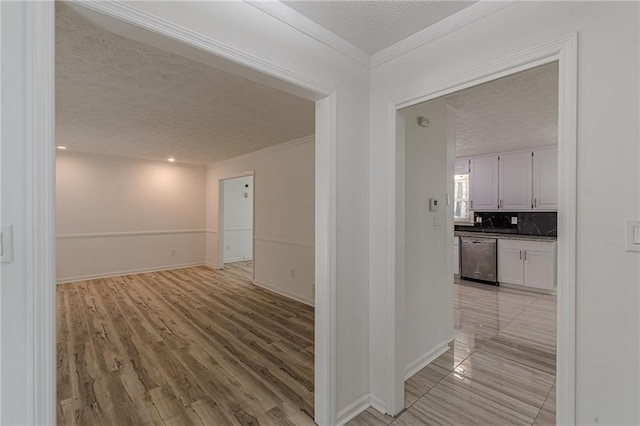 7020 Camp Valley Rd, Riverdale, GA 30296 - hall with light wood-style floors, a textured ceiling, crown molding, and baseboards