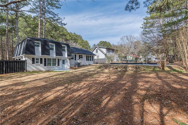 7020 Camp Valley Rd, Riverdale, GA 30296 - back of house featuring brick siding, mansard roof, fence, and a shingled roof