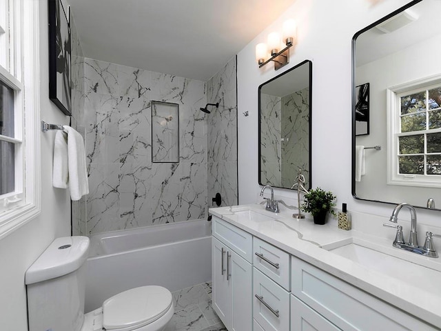 full bathroom featuring vanity, tiled shower / bath combo, and toilet