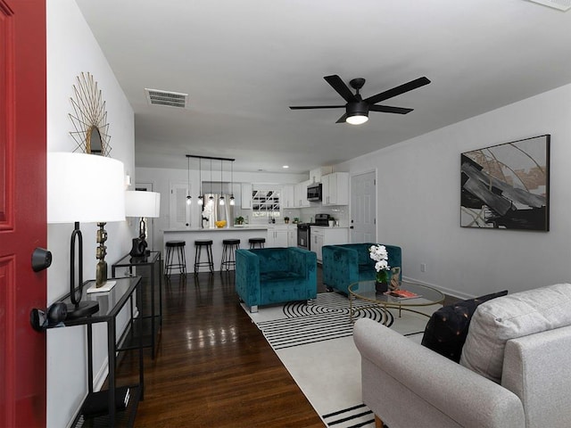 living room with ceiling fan and dark hardwood / wood-style floors