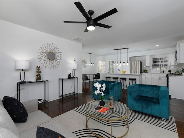 living room featuring ceiling fan and dark hardwood / wood-style floors