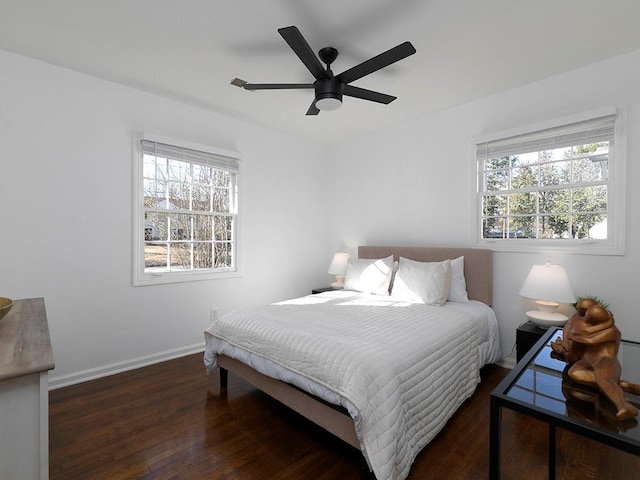 bedroom with multiple windows, dark wood-type flooring, and ceiling fan