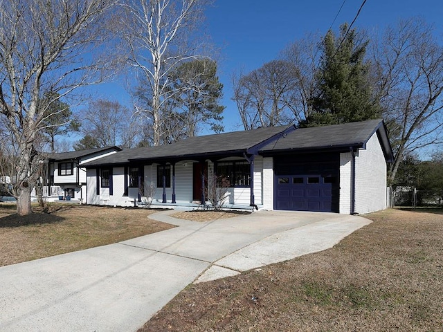 ranch-style home featuring a porch, a garage, and a front yard