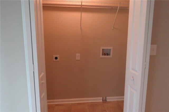 clothes washing area featuring electric dryer hookup, washer hookup, light tile patterned floors, baseboards, and laundry area