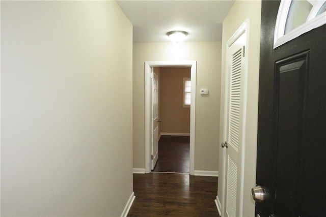 hallway with dark wood finished floors and baseboards