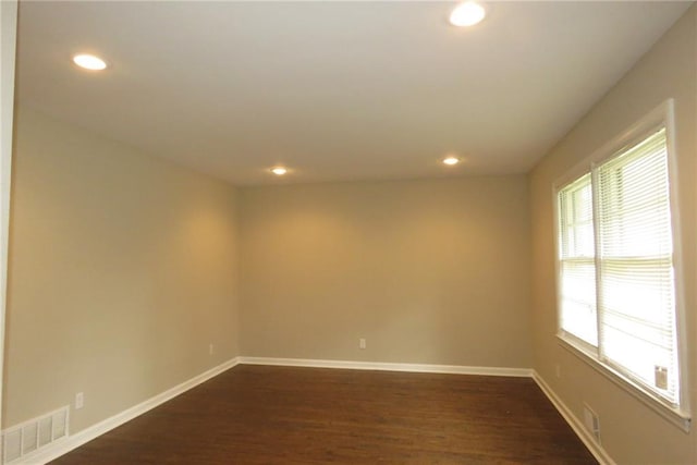 unfurnished room featuring dark wood finished floors, visible vents, recessed lighting, and baseboards