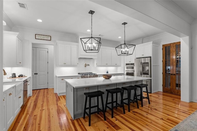 330 Shagbark Way, Harlem, GA 30814 - kitchen featuring appliances with stainless steel finishes, a chandelier, white cabinets, light wood-style floors, and light countertops