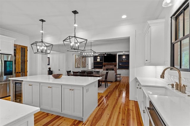 330 Shagbark Way, Harlem, GA 30814 - kitchen with beverage cooler, stainless steel appliances, light wood-style flooring, a sink, and a center island