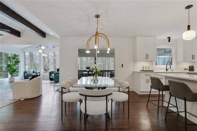 dining space featuring dark wood-style floors, beam ceiling, and a notable chandelier