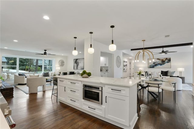 kitchen with visible vents, white cabinets, open floor plan, dark wood-type flooring, and oven