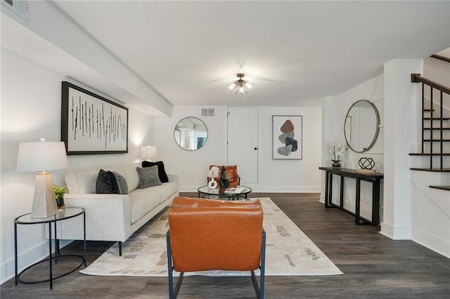 living area with dark wood-style floors, stairway, visible vents, and baseboards