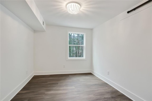 unfurnished room with dark wood-type flooring and baseboards