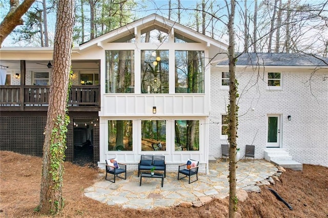 back of property with entry steps, a sunroom, a patio area, and brick siding