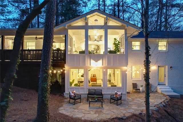 back of property featuring entry steps, a patio area, brick siding, and an outdoor living space