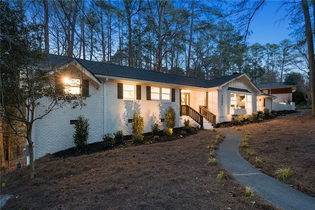 view of front of house with crawl space and brick siding