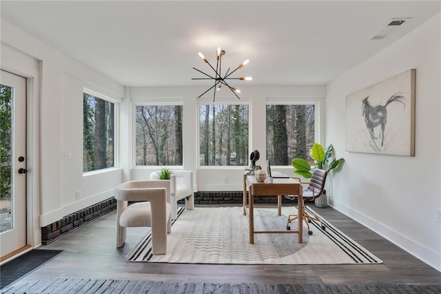 sunroom / solarium with a healthy amount of sunlight, visible vents, and a notable chandelier