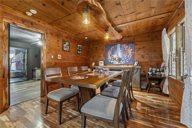 dining room featuring ceiling fan, wood walls, wood-type flooring, and wood ceiling