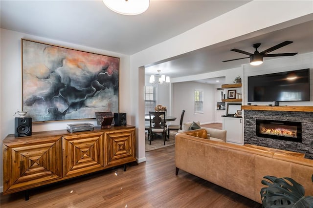 2189 Gordon Cir SE, Smyrna, GA 30080 - living area featuring wood finished floors, a glass covered fireplace, a chandelier, a ceiling fan, and baseboards