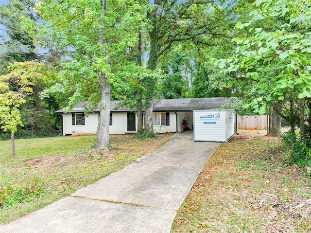 ranch-style home featuring driveway, a front yard, and fence