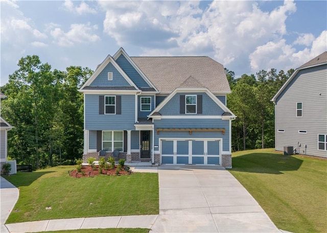 craftsman-style home featuring brick siding, a front yard, central AC, a garage, and driveway