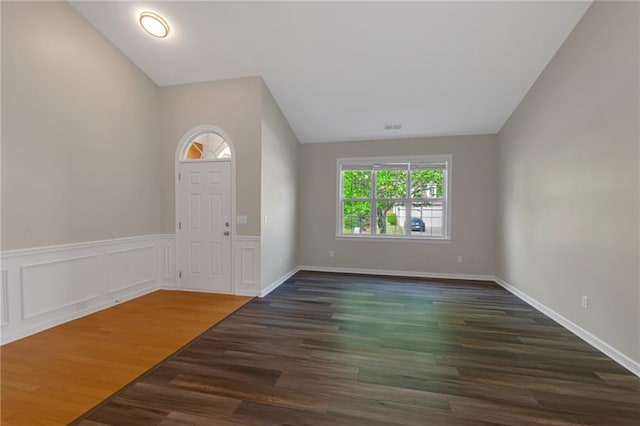 foyer featuring dark hardwood / wood-style flooring and vaulted ceiling