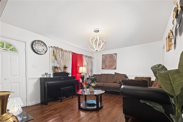 living room featuring a chandelier, baseboards, and wood finished floors