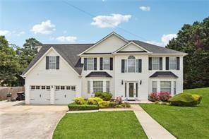 colonial-style house with concrete driveway, an attached garage, and a front lawn