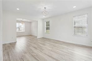 spare room featuring recessed lighting, baseboards, and wood finished floors