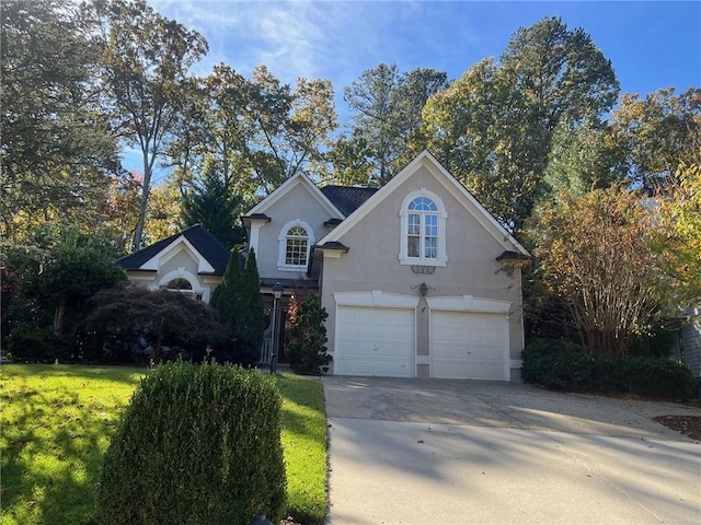 view of property featuring a garage and a front yard