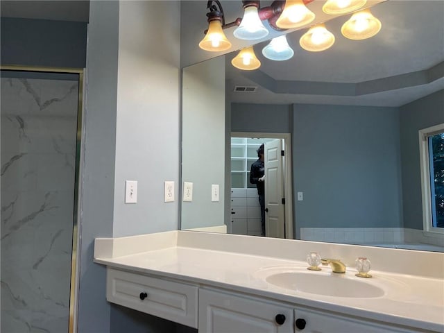 bathroom with vanity and a tile shower