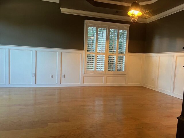 empty room featuring light hardwood / wood-style flooring, crown molding, and an inviting chandelier