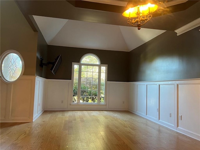 spare room with high vaulted ceiling, a notable chandelier, and light hardwood / wood-style floors