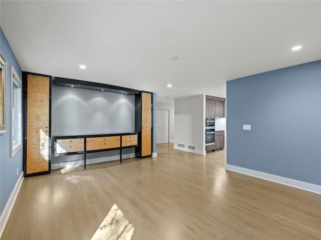 home theater room with light wood finished floors, recessed lighting, visible vents, and baseboards