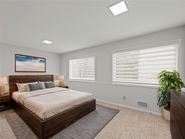 bedroom with carpet floors, visible vents, and baseboards