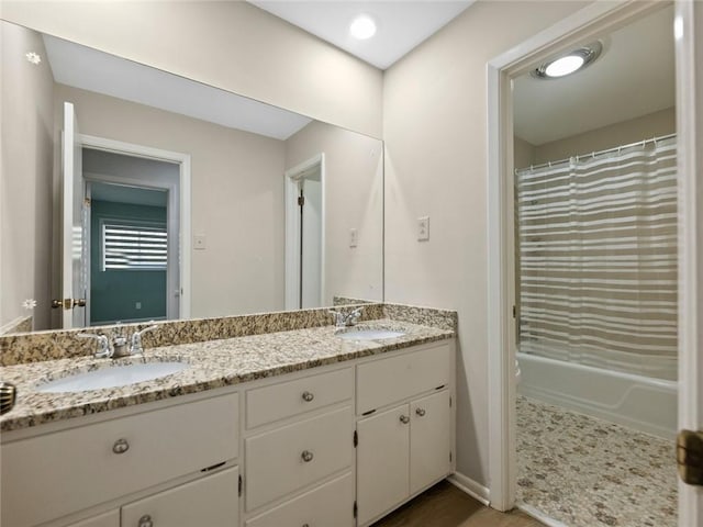 bathroom with double vanity, shower / bathtub combination with curtain, toilet, and a sink