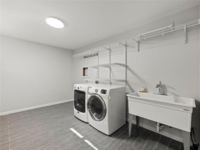 laundry area featuring wood finish floors, laundry area, washer and clothes dryer, and baseboards