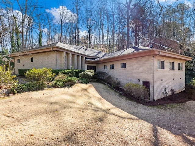 view of side of home featuring driveway and brick siding