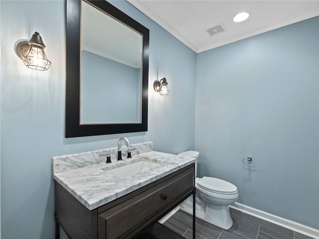 bathroom featuring baseboards, visible vents, toilet, ornamental molding, and vanity