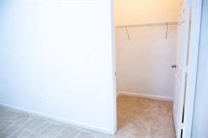 walk in closet featuring light colored carpet