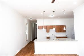 kitchen with hardwood / wood-style floors, decorative light fixtures, sink, kitchen peninsula, and ceiling fan