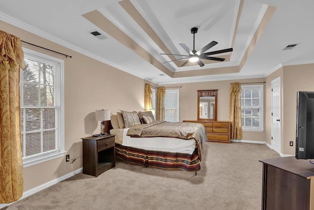 carpeted bedroom with ceiling fan, a raised ceiling, and crown molding